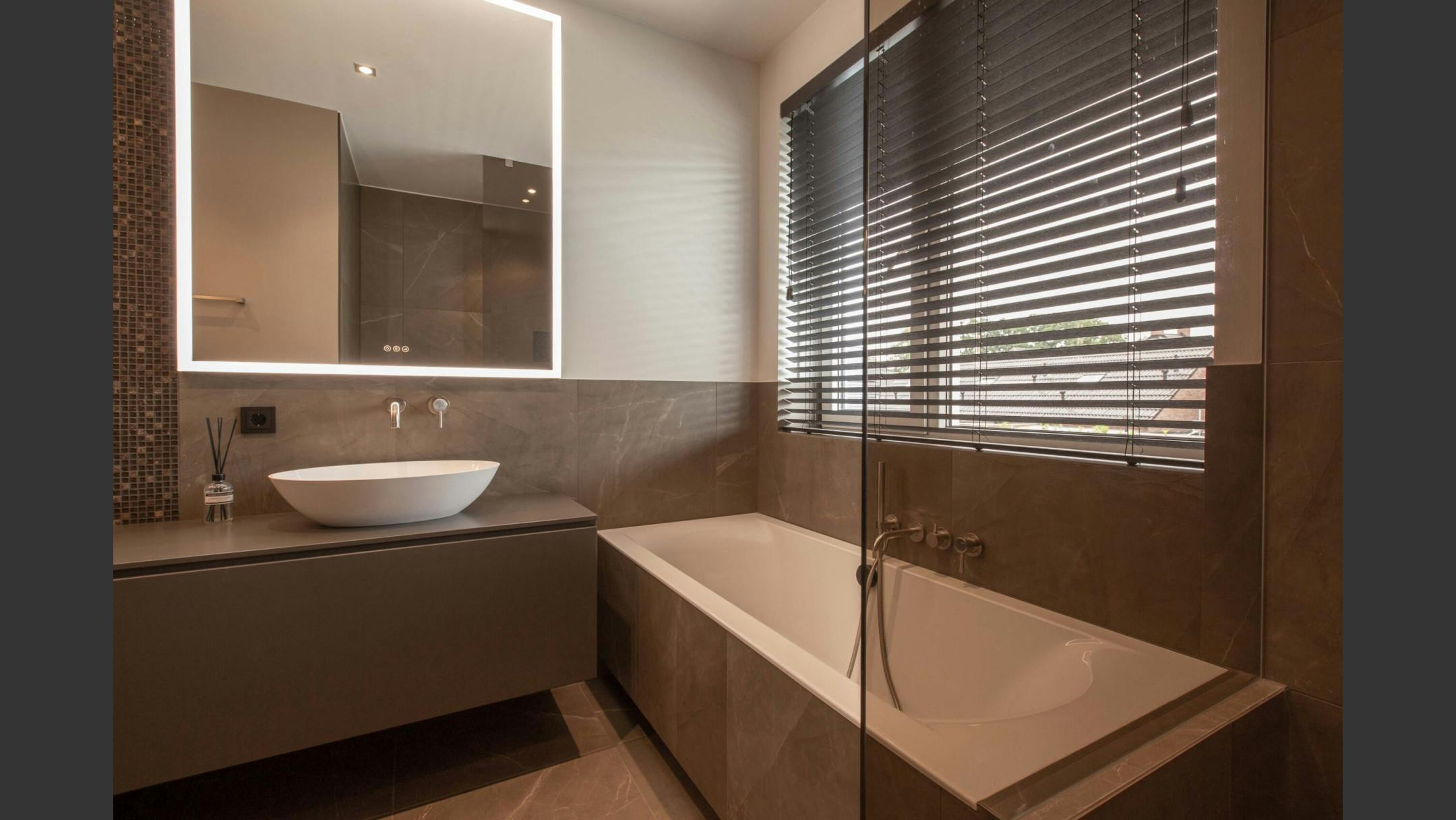 Een bad en wastafel met strakke afwerking voor een luxe moderne uitstraling