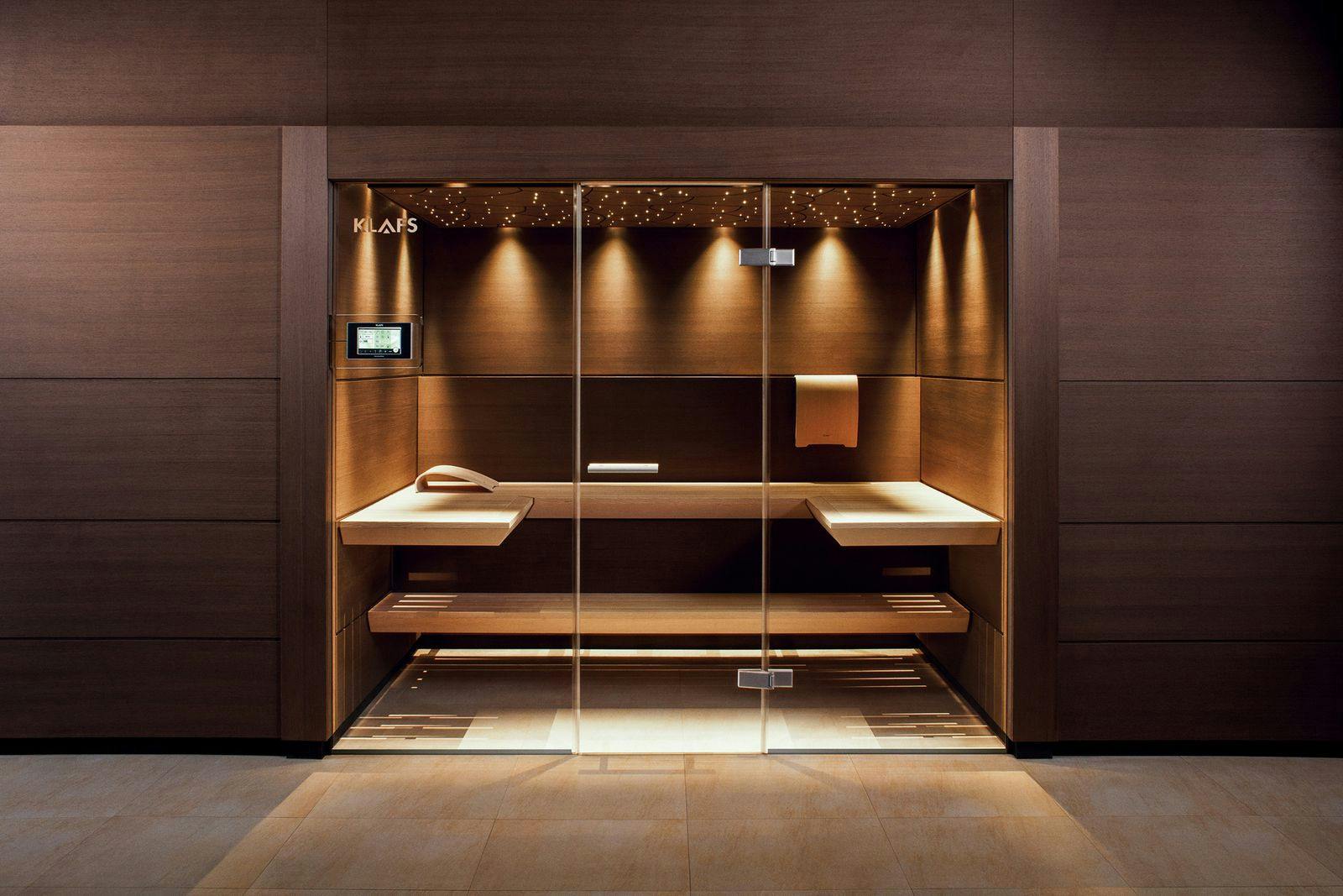 Een op maat gemaakte sauna in de muur van een luxe badkamer.