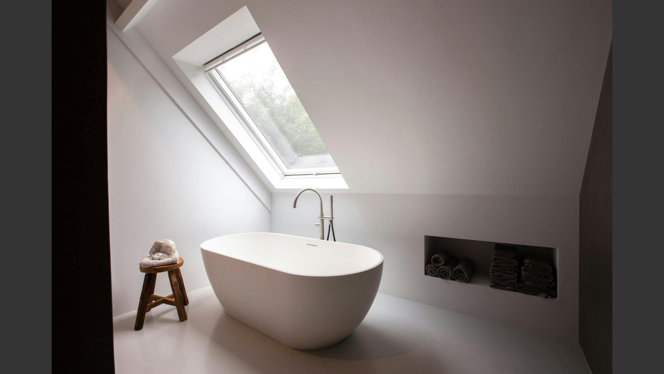 Een voorbeeld van een scandinavische badkamer met witte kleuren, een subtiel houten accent en een vrijstaand bad.