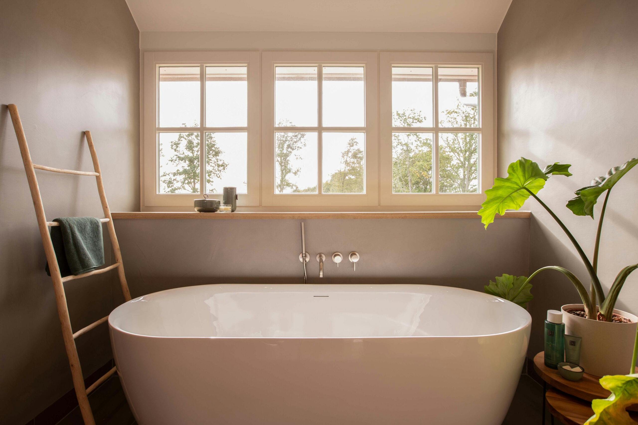 De donkere Scandinavische badkamerstijl maakt gebruikt van donkergrijze kleuren op de muur en houten accenten in bijvoorbeeld meubels.