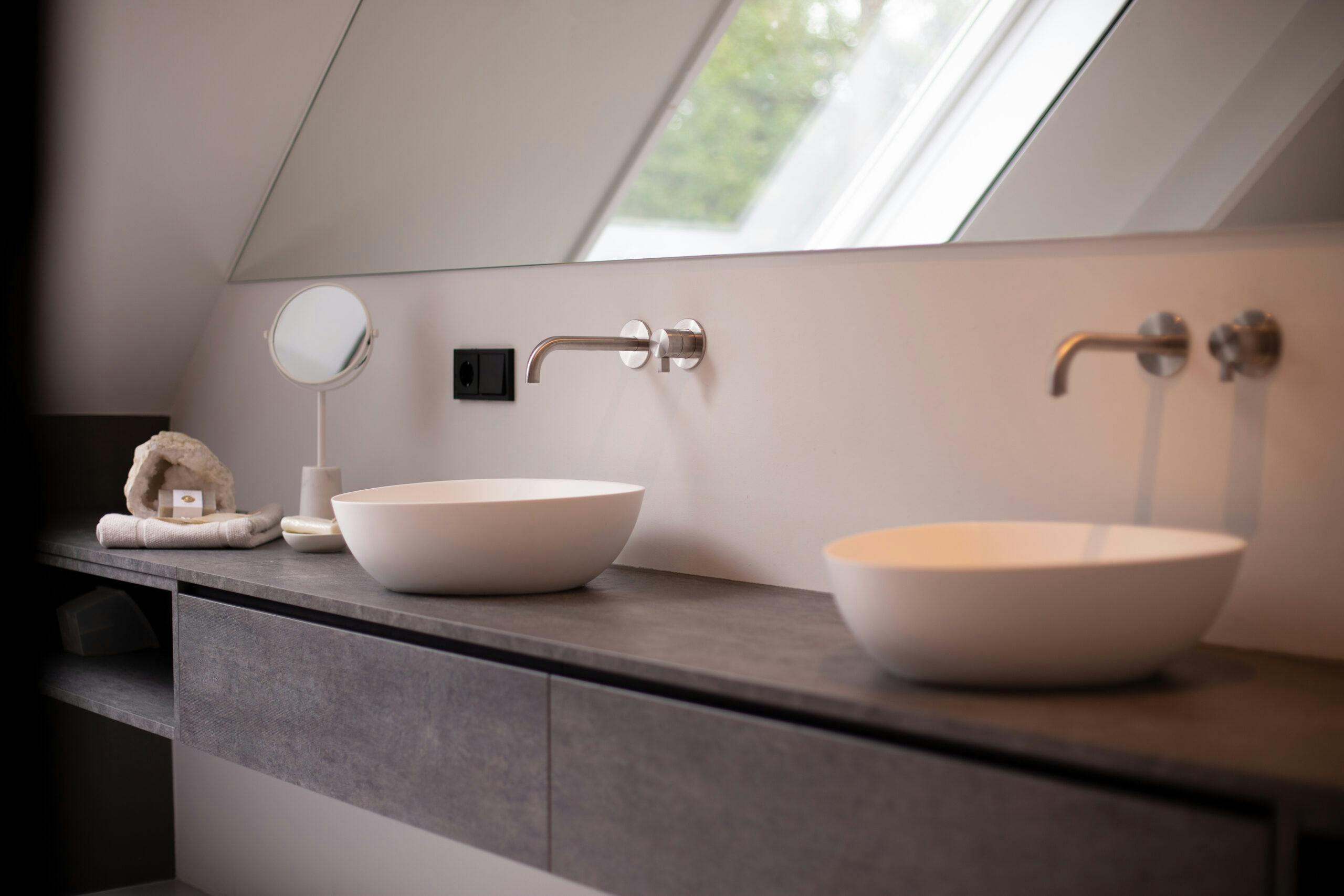 Het scandinavische badkamer design kenmerkt zich door het hoekige patroon van de muur achter de spiegel.