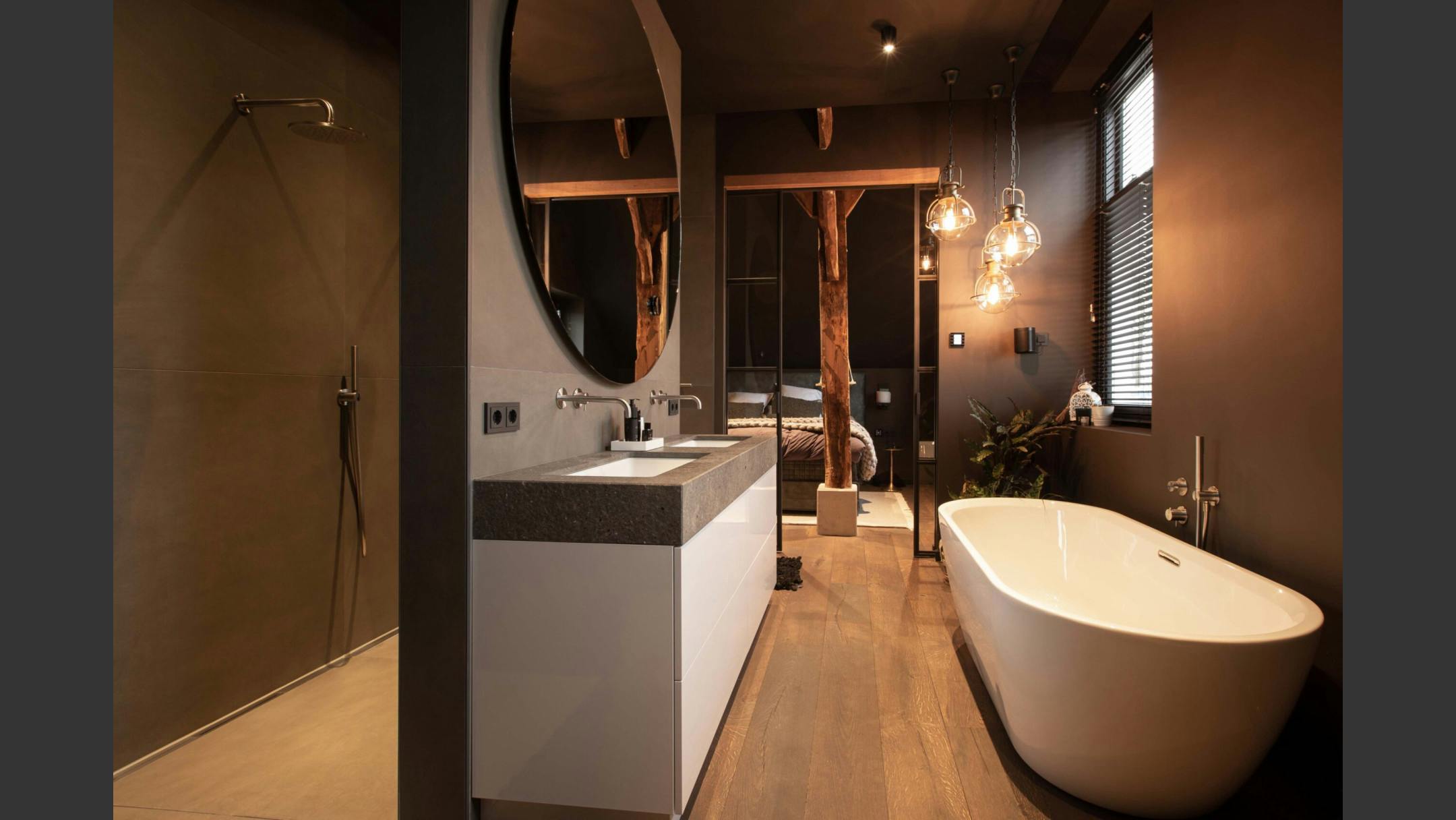 Op maat gemaakte luxe badkamer met vrijstaand bad, inloopdouche en houttinten.